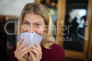 Beautiful woman holding cards in bar