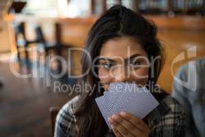 Beautiful woman holding cards in bar