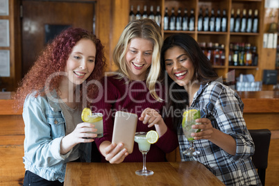 Female friends looking their photos on mobile phone