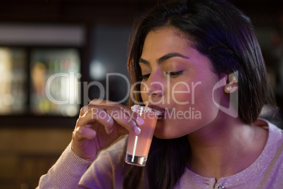 Woman drinking tequila shot