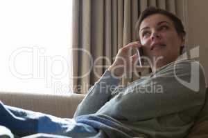 Woman talking on mobile phone in living room
