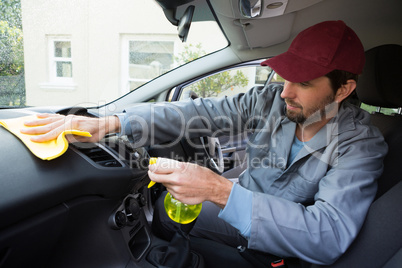 Worker spraying water on car dashboard