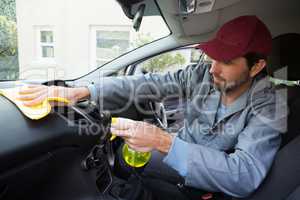 Worker spraying water on car dashboard