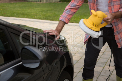 Auto service staff cleaning a car with rotating wash brush