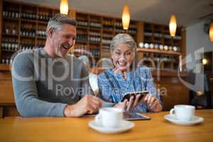 Happy senior couple looking their photos on mobile phone
