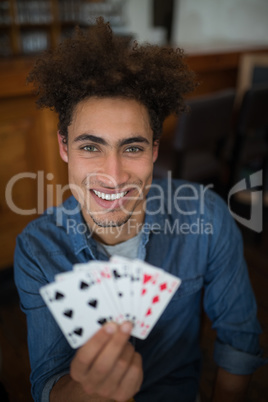 Smiling man showing cards in bar