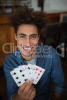 Smiling man showing cards in bar