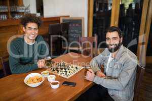 Two friends having glass of beer in bar