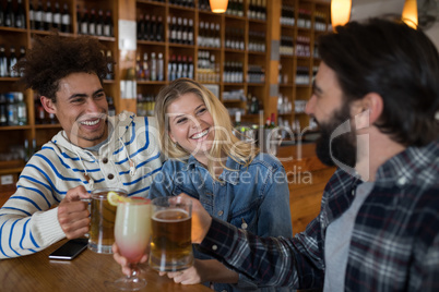 Friends toasting glass of drinks in bar