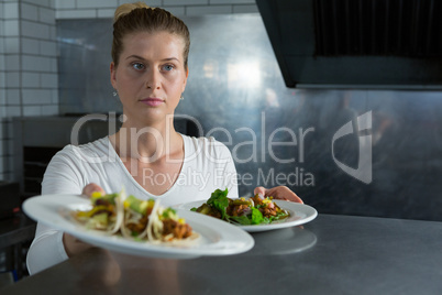 Female chef holding food plate