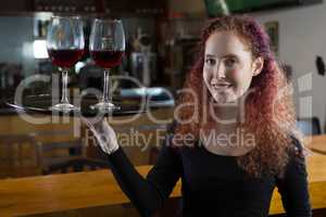 Beautiful waitress holding wine glasses