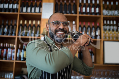 Waiter shaking cocktail in bar