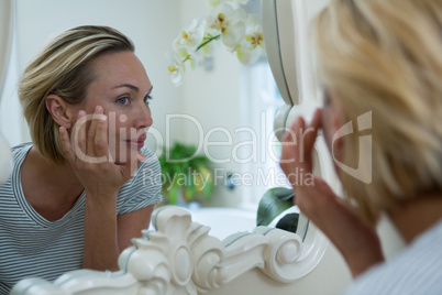Woman looking in mirror of bathroom