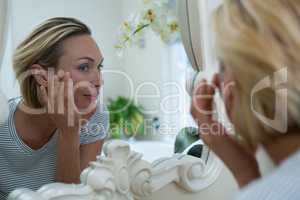 Woman looking in mirror of bathroom