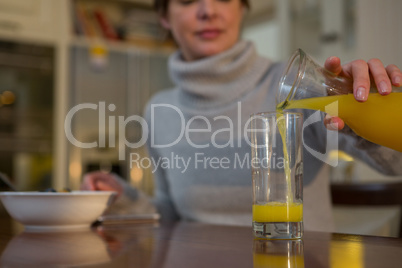 Woman pouring juice in glass