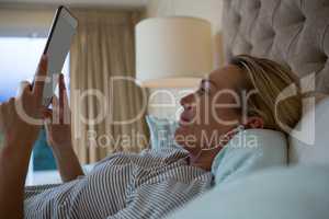 Woman using laptop while listening music on headphones