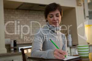 Beautiful woman writing in organizer
