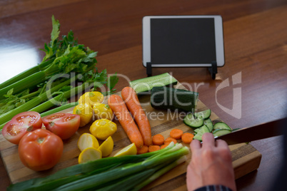 Woman cutting vegetable in kitchen