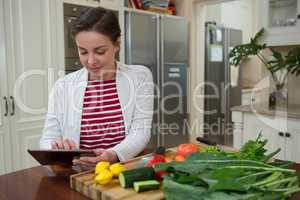 Woman using digital tablet in kitchen