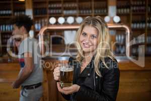 Beautiful woman holding glass of beer in bar