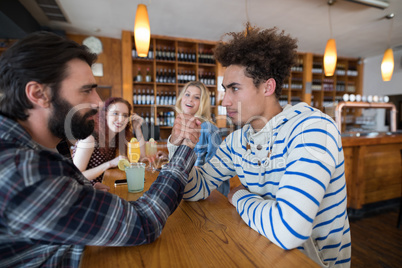 Two men arm wrestling in bar