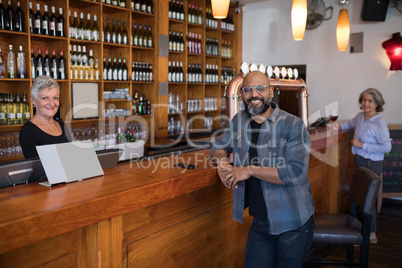 Man and senior waitress looking at camera in bar