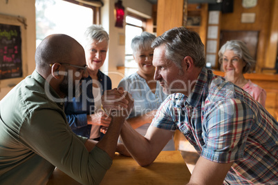 Happy friend arm wrestling each other