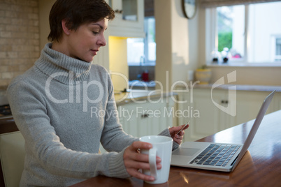 Woman doing online shopping with a credit card on laptop