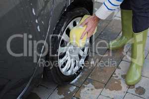 Auto service staff washing a car with sponge