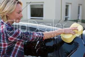 Woman cleaning her car with sponge