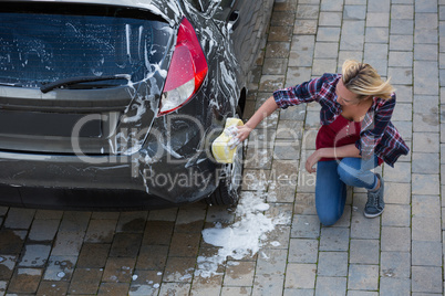 Woman cleaning her car with sponge