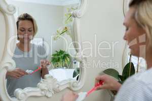 Reflection of woman removing toothpaste