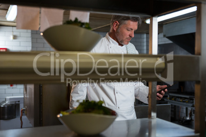 Male chef using mobile phone