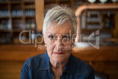 Confident senior woman looking at camera in restaurant