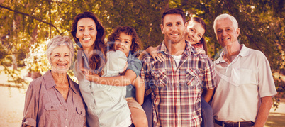 Extended happy family standing together in park