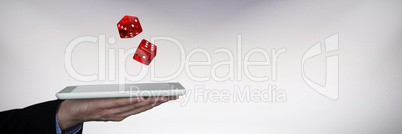 Composite image of cropped hand on businessman holding digital tablet