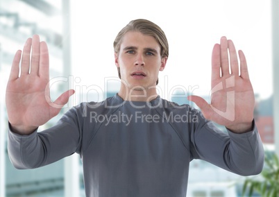 Businessman holding hands up in front of office