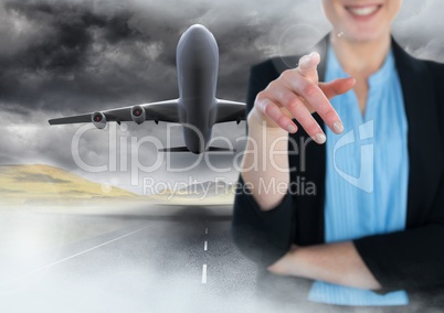 Businesswoman touching air in front of flying plane on runway