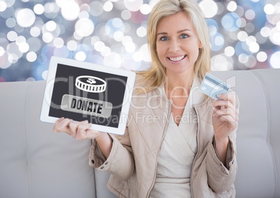 Woman holding tablet with donate button and money for charity