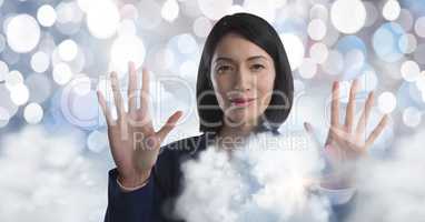 Clouds surrounding Businesswoman touching air in front of sparkles