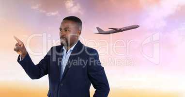 Businessman pointing up to air in front of plane