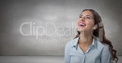 Woman looking up and laughing with grey background
