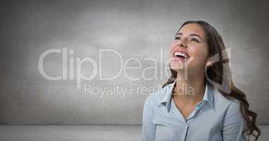 Woman looking up and laughing with grey background
