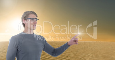 Businessman touching air in goggles in front of desert planet sun
