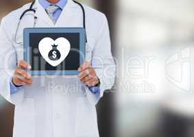 Doctor holding tablet with heart and money bag icon