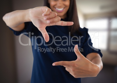 Businesswoman making invisible shape with hands in front of blurred background