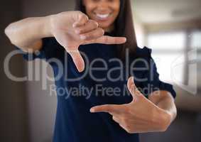 Businesswoman making invisible shape with hands in front of blurred background