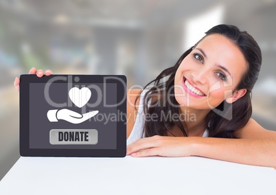 Woman holding tablet with donate button and hand giving heart icon for charity