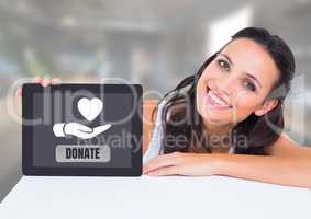 Woman holding tablet with donate button and hand giving heart icon for charity