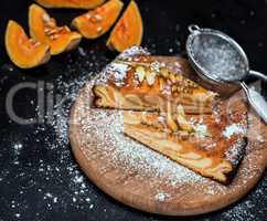 pieces of pumpkin pie on a round wooden board